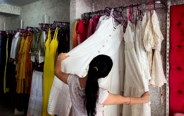 Cliente escolhendo roupa na loja Tita Confeces, em Rondonpolis